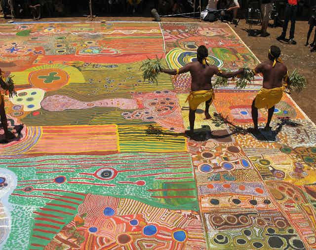 Indigenous dancers from WA's remote Kimberley region standing on the Ngurrara Canvas.
