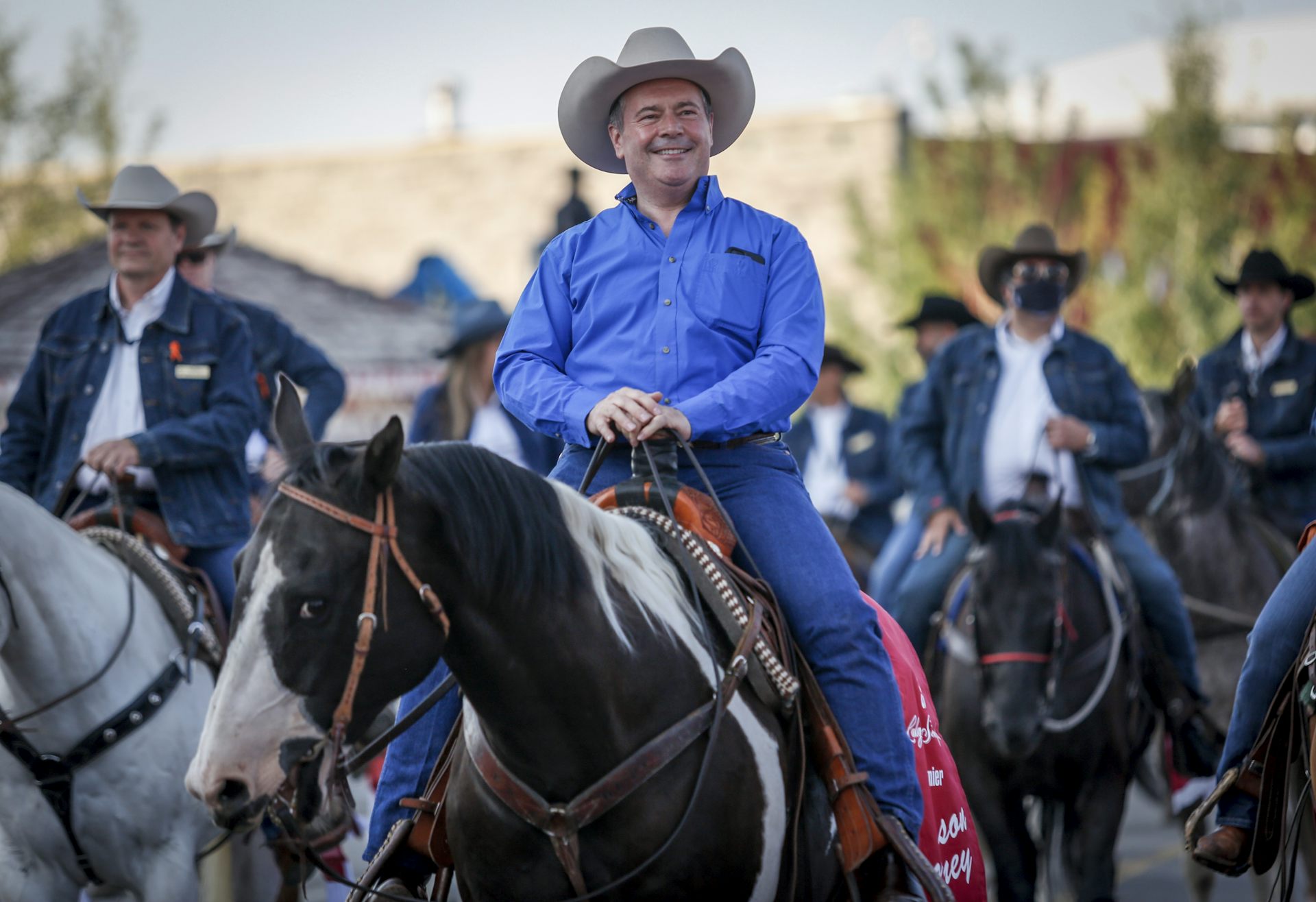 Jason Kenney rides a horse wearing a cowboy hat.
