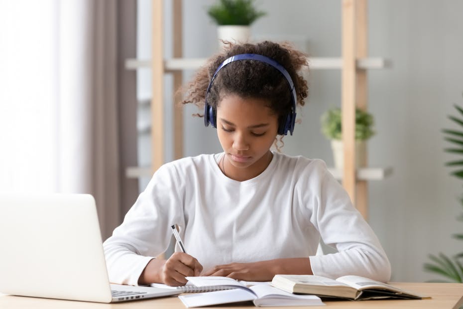 A student in front of laptop with headphones.