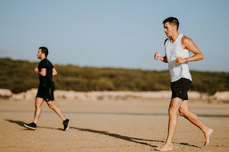 Deux hommes courent sur la plage sans trop forcer