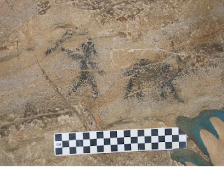 dark silhouette figures of a human and a quadruped on stone