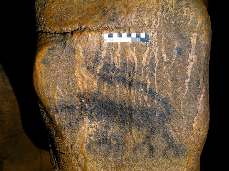 dark silhouetted shape of a four-legged creature on stone