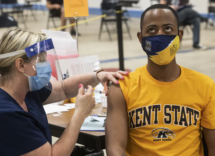 A young man looking upward while getting an injection