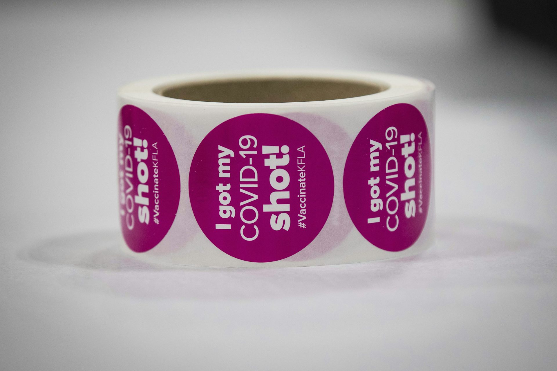 A roll of pink stickers reading 'I got my COVID-19 shot!'