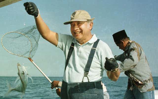 Soeharto catching a fish.