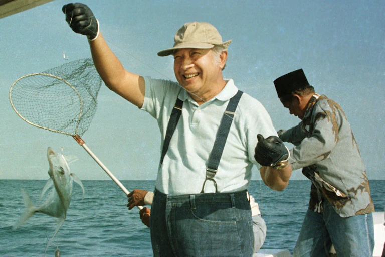 Soeharto catching a fish.