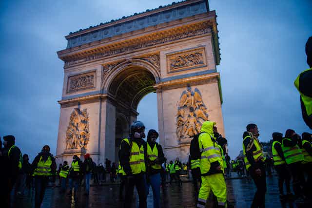 Paris, France - December 01, 2018 : The Gilets Jaunes, or “Yellow Vest”, protestors clash with police while demonstrating against the government of President Macron near the Arc de Triomphe.