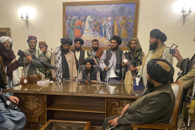 Taliban fighters sit in the presidential palace in Kabul.