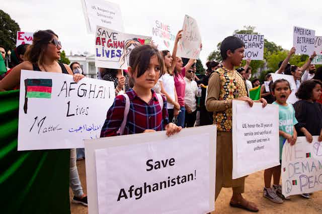 Women and girls protest outside the White House for Afghan rights.