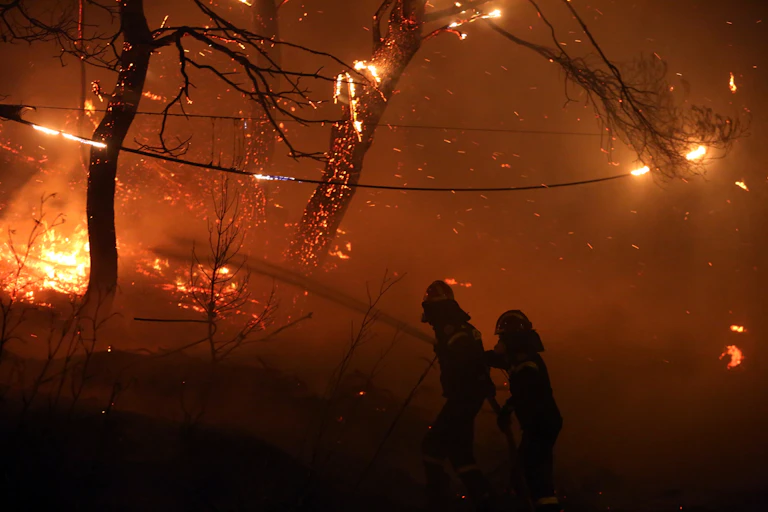 two people walk through fireground