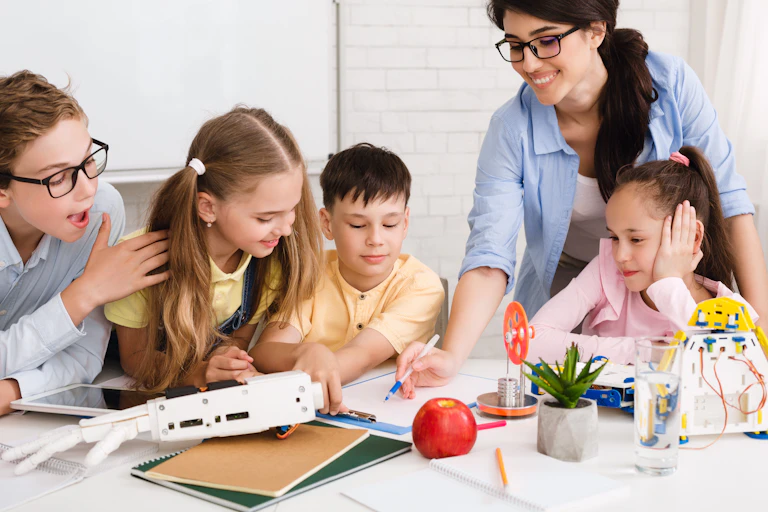 Kids working on a project with teacher showing them something.
