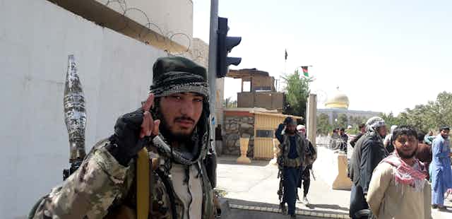Un militante talibán mira hacia la cámara y levanta el dedo índice