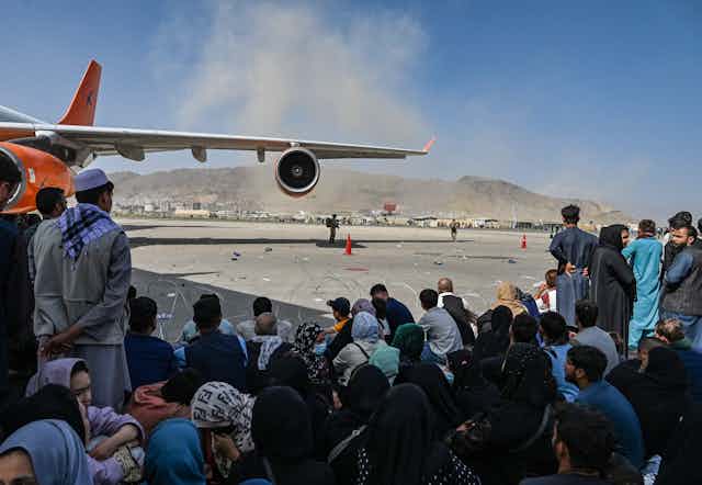 Afghan people waiting to leave the Kabul airport in Kabul on Aug.16, 2021.