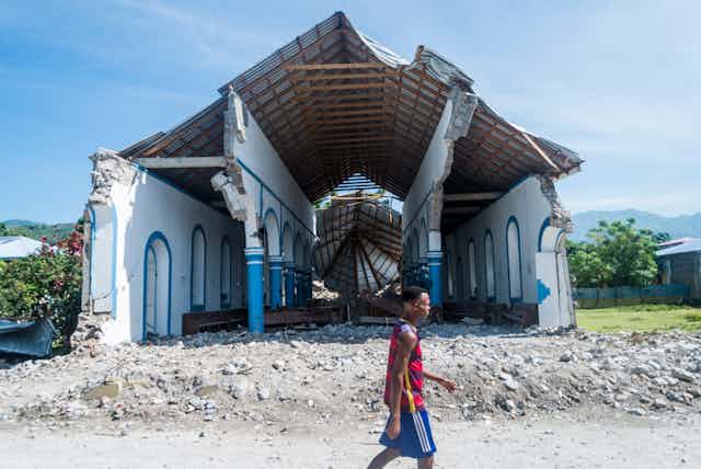 A man walks past a church destroyed during an earthquake in Haiti.