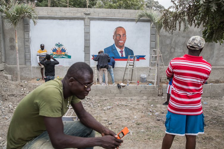 Local artists paint a mural of slain president Jovenel Moise.