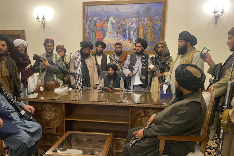 Trois combattants talibans montent la garde à un poste de contrôle.