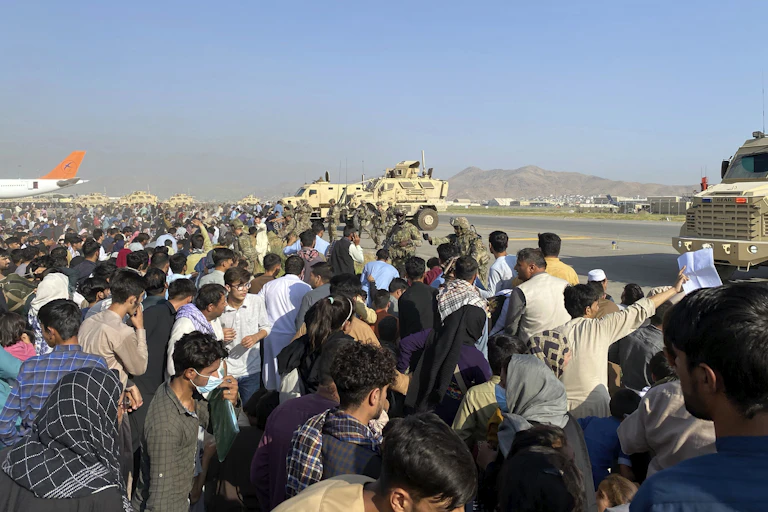 A crowd of Afghans rushing onto the tarmac at the Kabul airport.