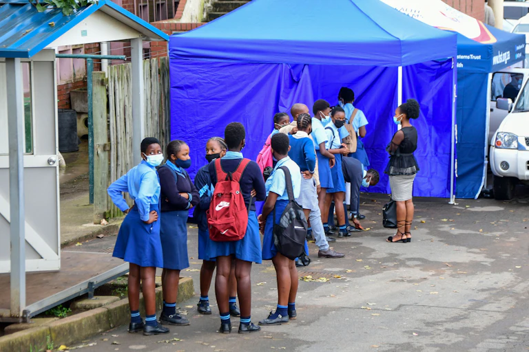 girls in school uniform waiting in line.