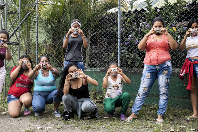 A group of people posing for a photo while holding cameras themselves