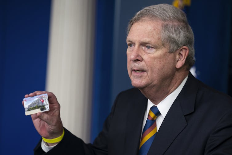 Agriculture Secretary Tom Vilsack holds up a Supplemental Nutrition Assistance Program Electronic Benefits Transfer (SNAP EBT) card.