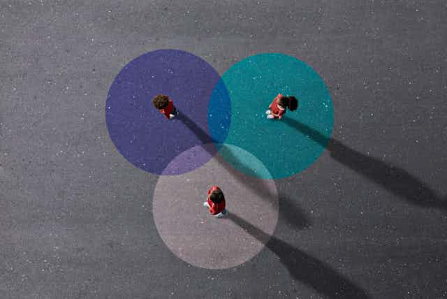 Three children in school uniforms stand on painted Venn diagram