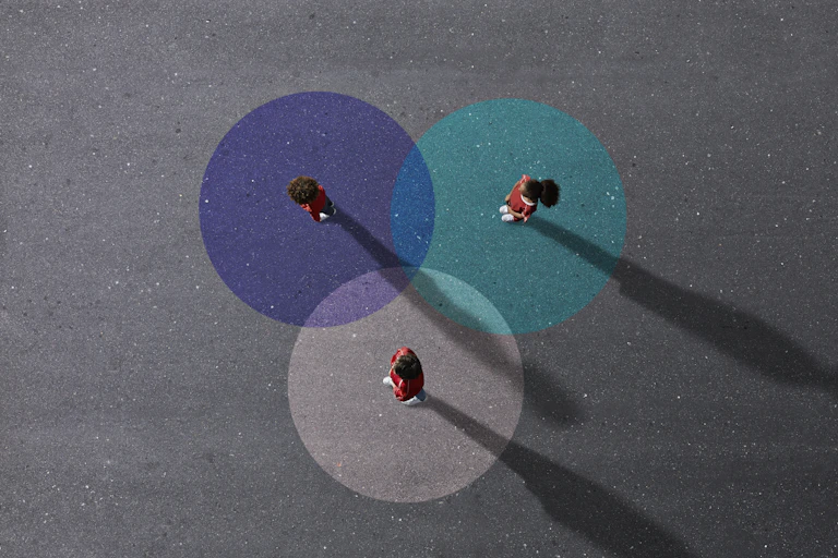 Three children in school uniforms stand on painted Venn diagram
