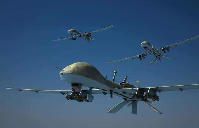 three flying drones armed with missiles