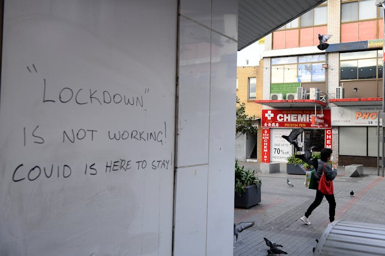 Graffiti that reads: 'Lockdown is not working! COVID is here to stay.'