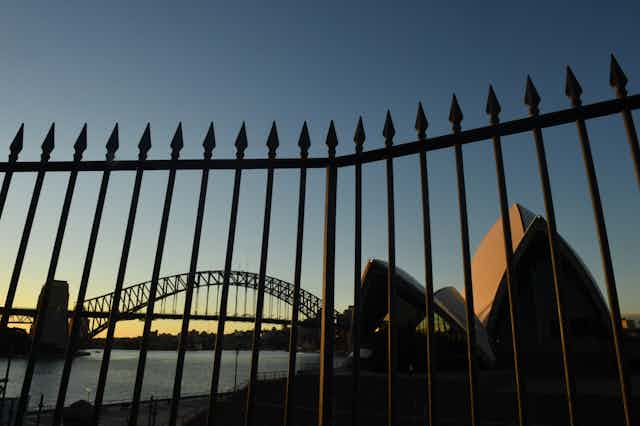 Sydney Harbour Bridge behind a fence at sunset