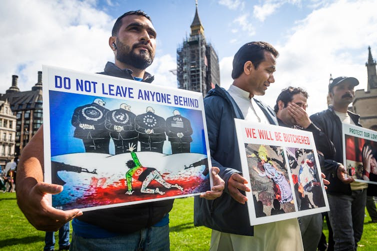 Protestors hold placards