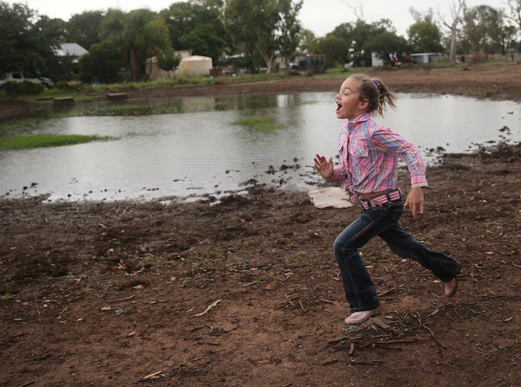 girl runs past dam