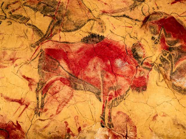 Pintura rupestre de un bisonte rojo en la pared de una cueva
