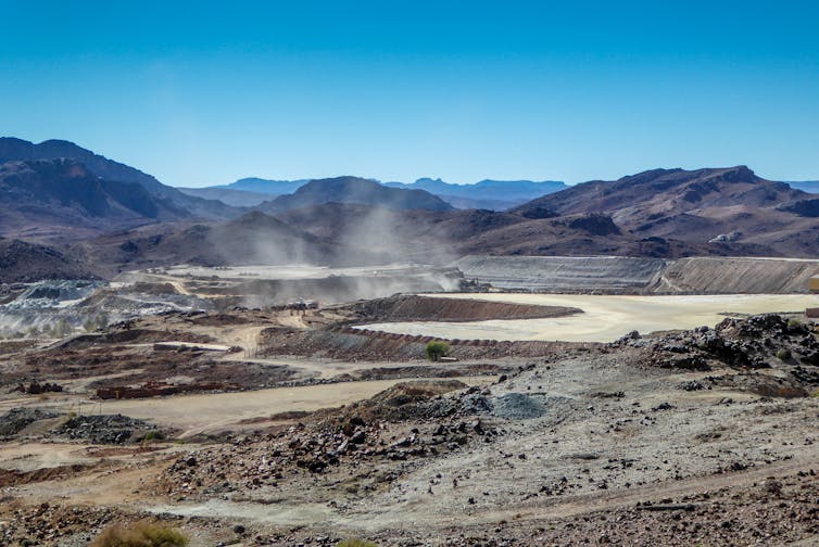 A rocky landscape with ponds full of industrial waste.