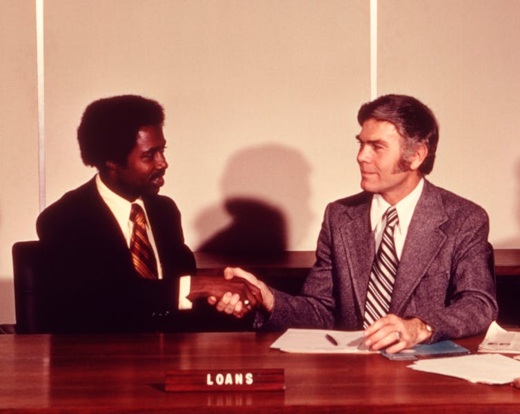 Man receiving loan from bank manager