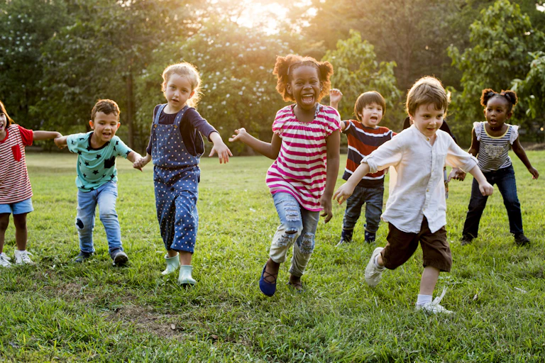 Children run across grass.