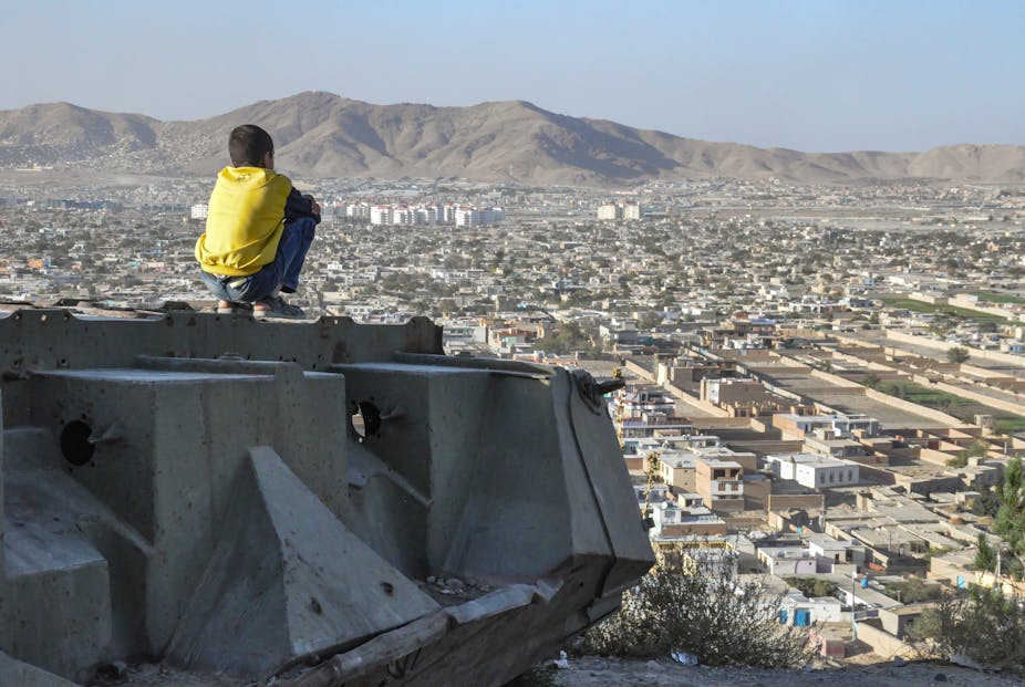 Un jeune garçon contemple Kaboul depuis un char détruit, 2012.