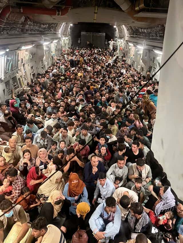 Afghan citizens, inside a U.S. Air Force transport, await takeoff from Karzai Airport.