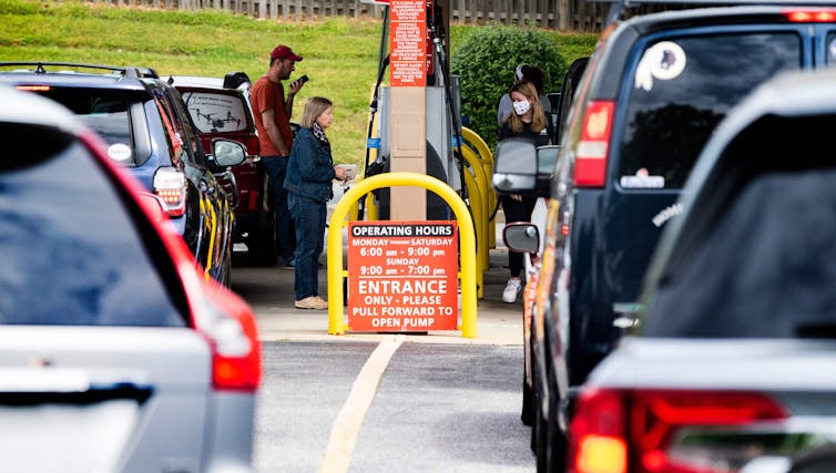 Lines of cars wait for gas pumps at a busy station.