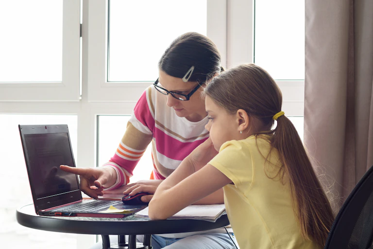 Mother and daughter working together on a laptop