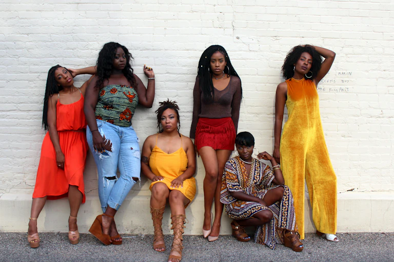 Group of women posing against a wall