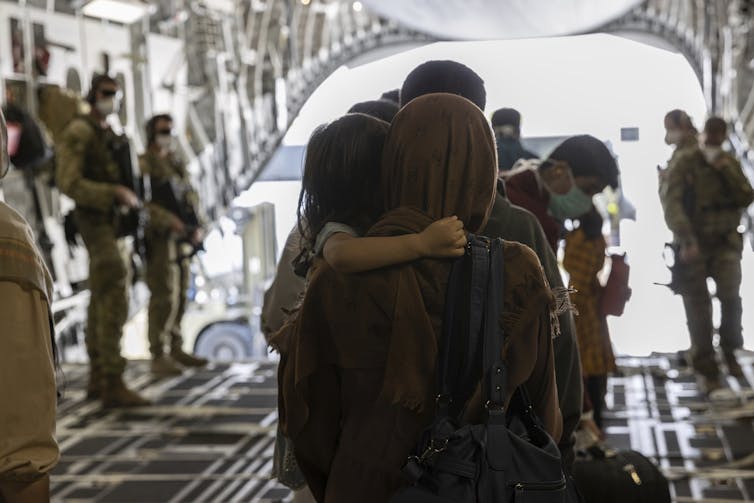 Afghan mother and child leave an ADF flight to Australia.