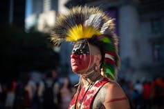 A man poses in ancestral garb.