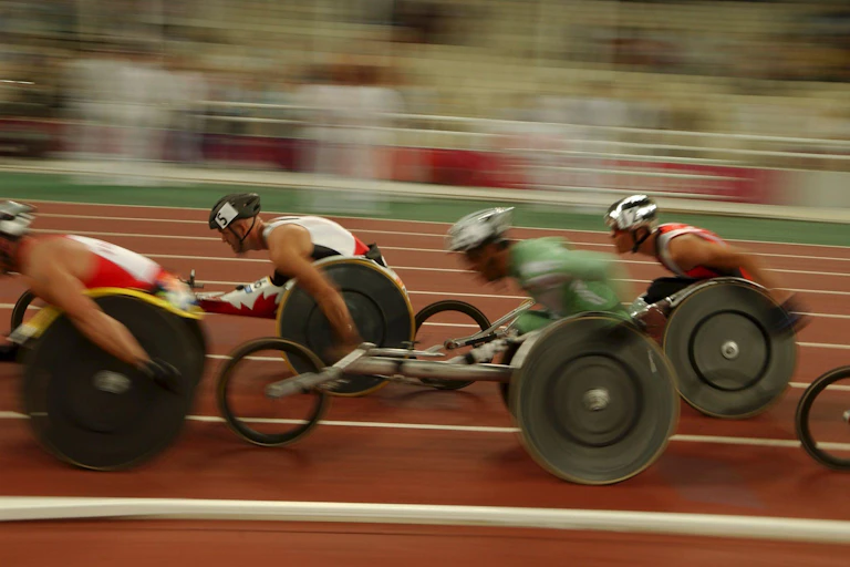 A blurred action shot of wheelchair racers on an Olympic track