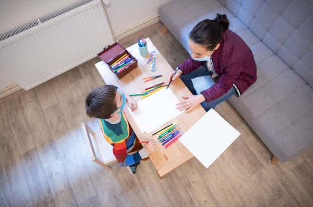 Child and therapist draw together at table