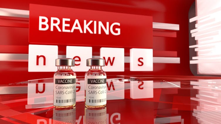 Red breaking news banner behind two vials of COVID-19 vaccine.