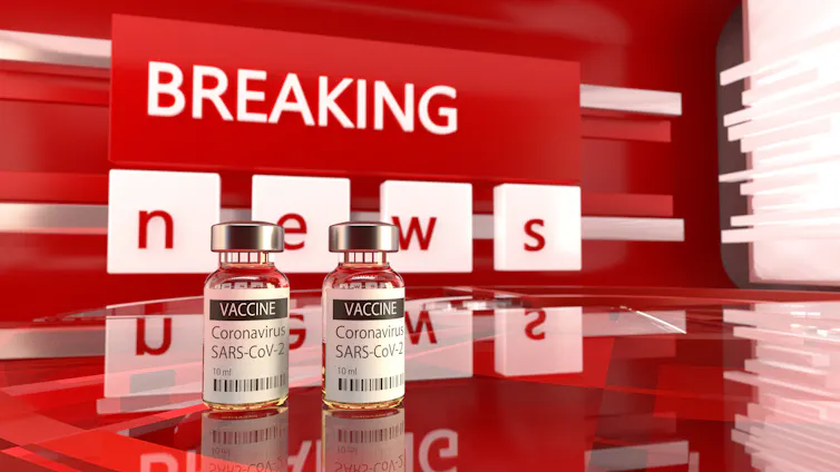 Red breaking news banner behind two vials of COVID-19 vaccine.