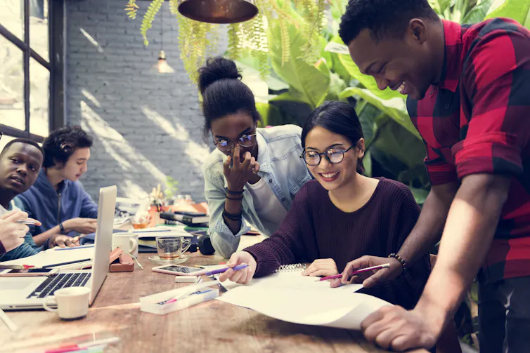 A group of people working together at a desk.