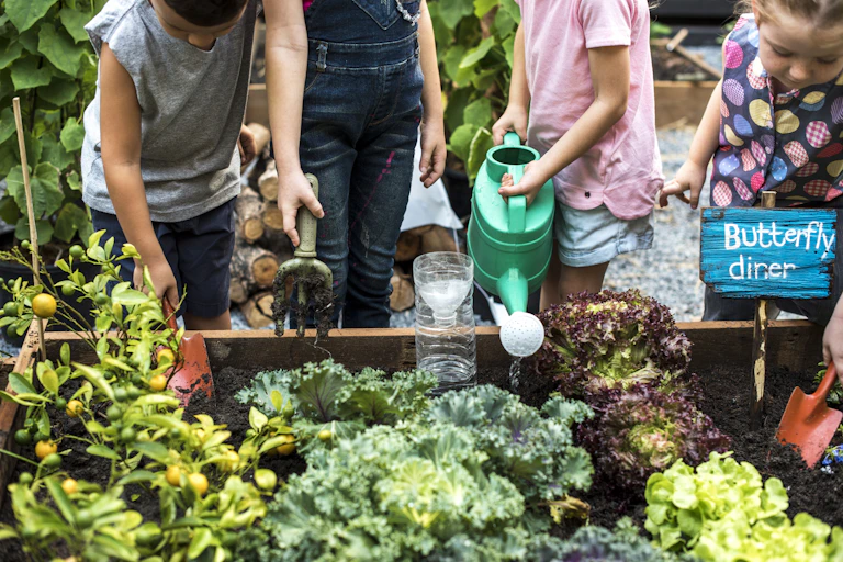 Children water plants at a community garden.