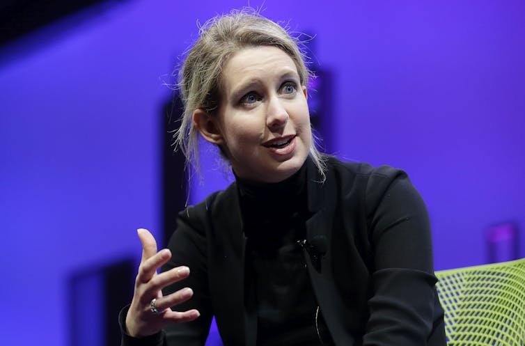 Elizabeth Holmes gestures as she speaks at a conference.