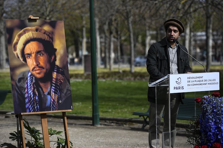Afghan resistance leader Ahmad Massoud stands next to a portrait of his father Ahmad Shah Massoud.